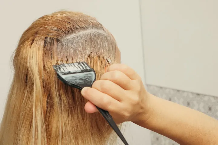 Frau färbt sich die Haare selbst